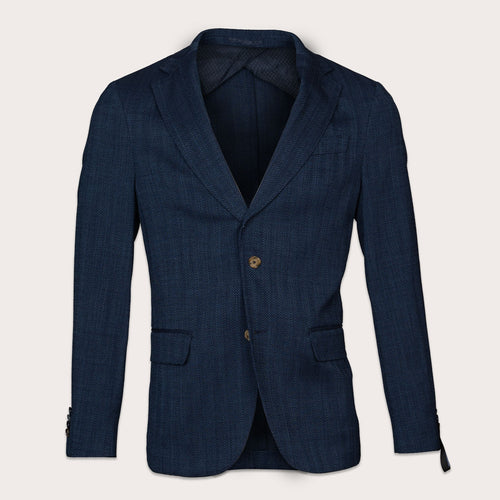 A dark navy blue textured blazer with a single gold button, displayed on a light beige background. Sand Copenhagen Blazers available at Sakks Menswear in Southampton.