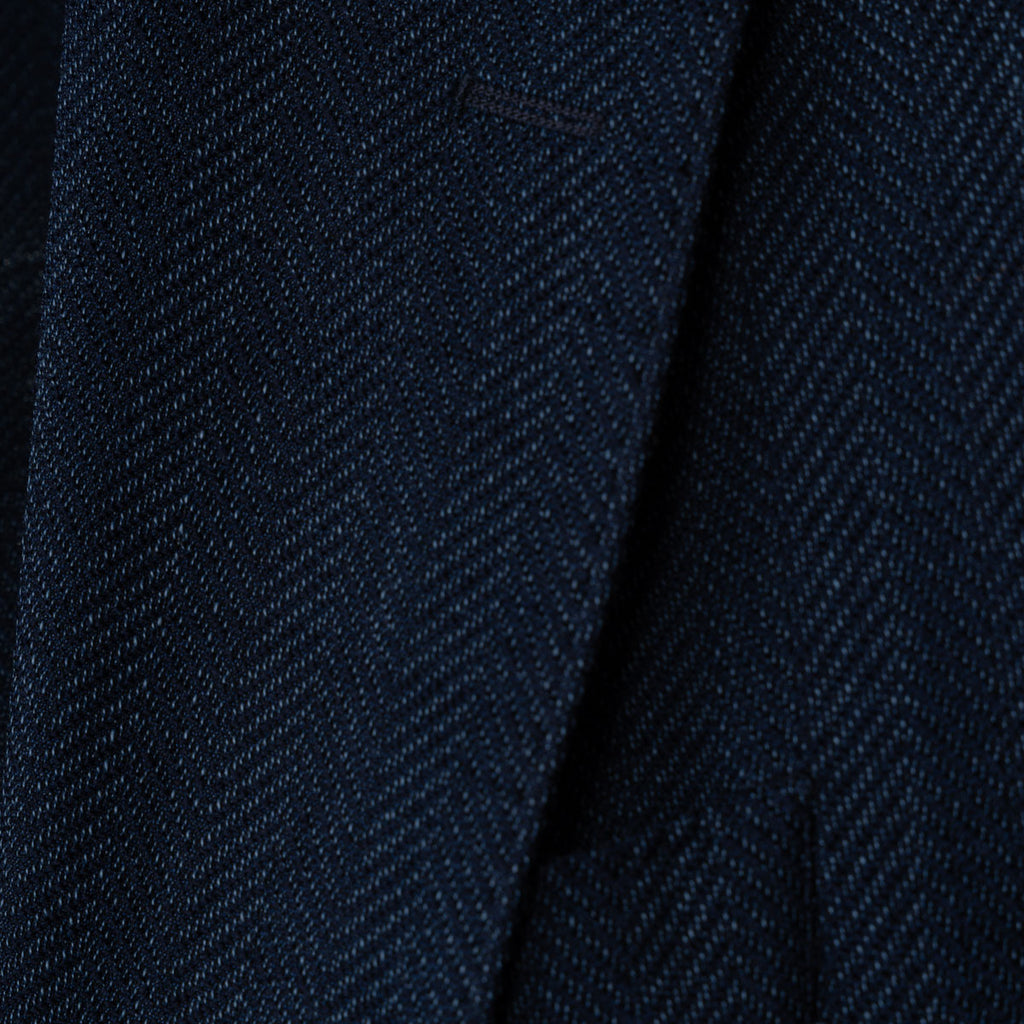Close-up of a dark navy blue textured fabric with a fine woven herringbone pattern. Sand Copenhagen Blazers available at Sakks Menswear in Southampton.