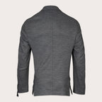 A dark gray heathered blazer shown from the back, featuring a central seam, notched lapels, and side slits near the hem, displayed on a light beige background. Sand Copenhagen Blazer available at Sakks Menswear in Southampton.