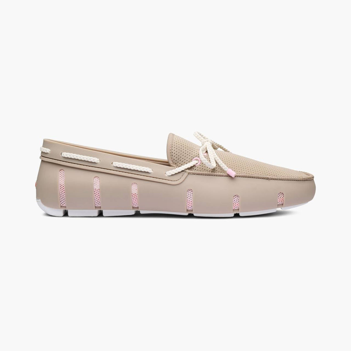 A single beige slip-on loafer with white rope laces and pink decorative accents on the sole, shown in profile against a light gray background. SWIMS Loafers available at Sakks Menswear in Southampton.