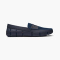 A single navy blue slip-on loafer with a textured knit upper and a molded sole, shown in a side profile on a light gray background. SWIMS Loafers available at Sakks Menswear in Southampton.