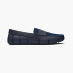 A single navy blue slip-on loafer with a textured knit upper and a molded sole, shown in a side profile on a light gray background. SWIMS Loafers available at Sakks Menswear in Southampton.