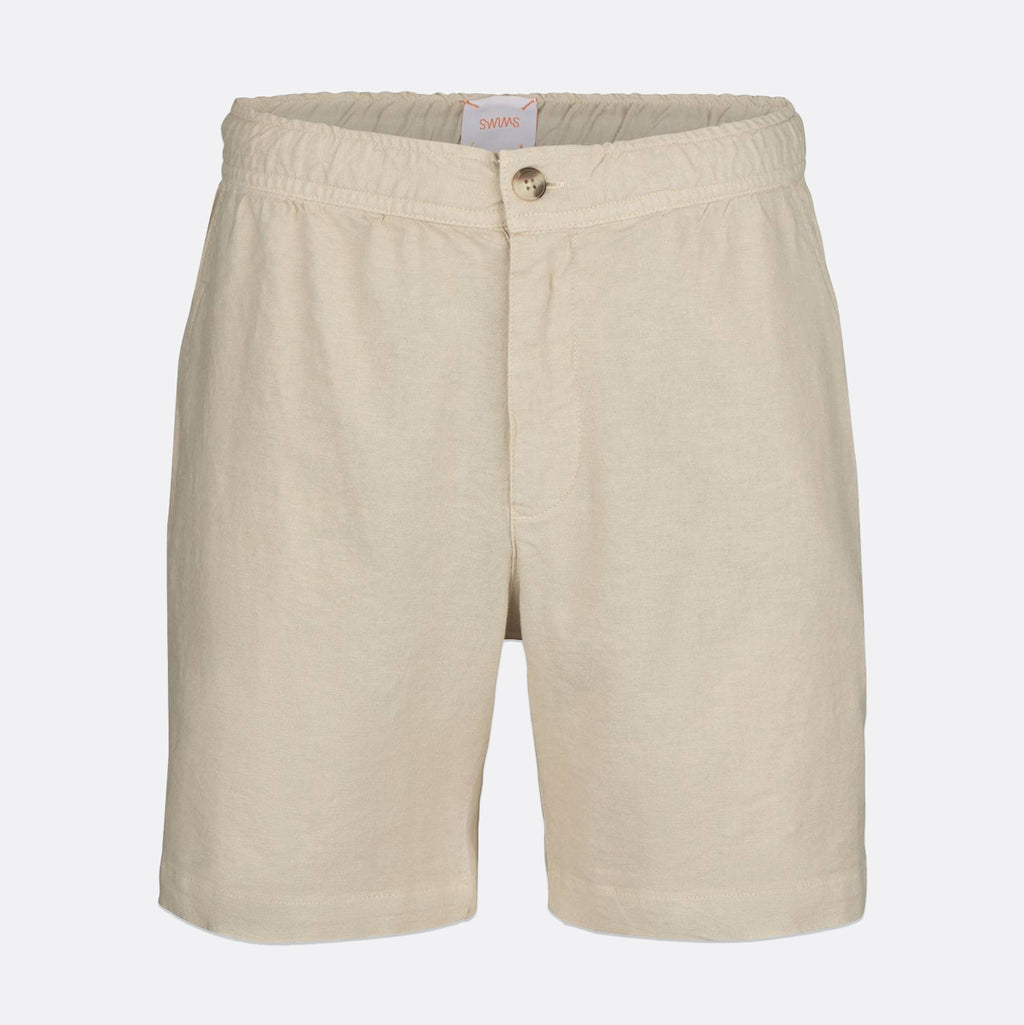 Beige cotton shorts with an elastic waistband and a single button closure, shown against a light gray background. SWIMS Shorts available at Sakks Menswear in Southampton.