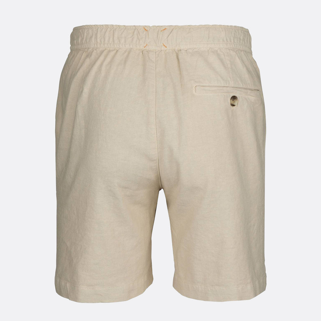 Beige linen shorts with an elastic waistband, a side welt pocket, and a small button closure, shown from the back on a light gray background. SWIMS Shorts available at Sakks Menswear in Southampton.
