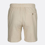 Beige linen shorts with an elastic waistband, a side welt pocket, and a small button closure, shown from the back on a light gray background. SWIMS Shorts available at Sakks Menswear in Southampton.