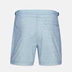 Light blue swim trunks with a small dark blue geometric pattern, featuring a side pocket and a waistband with side tabs, shown against a light gray background. SWIMS Swim Shorts available at Sakks Menswear in Southampton.