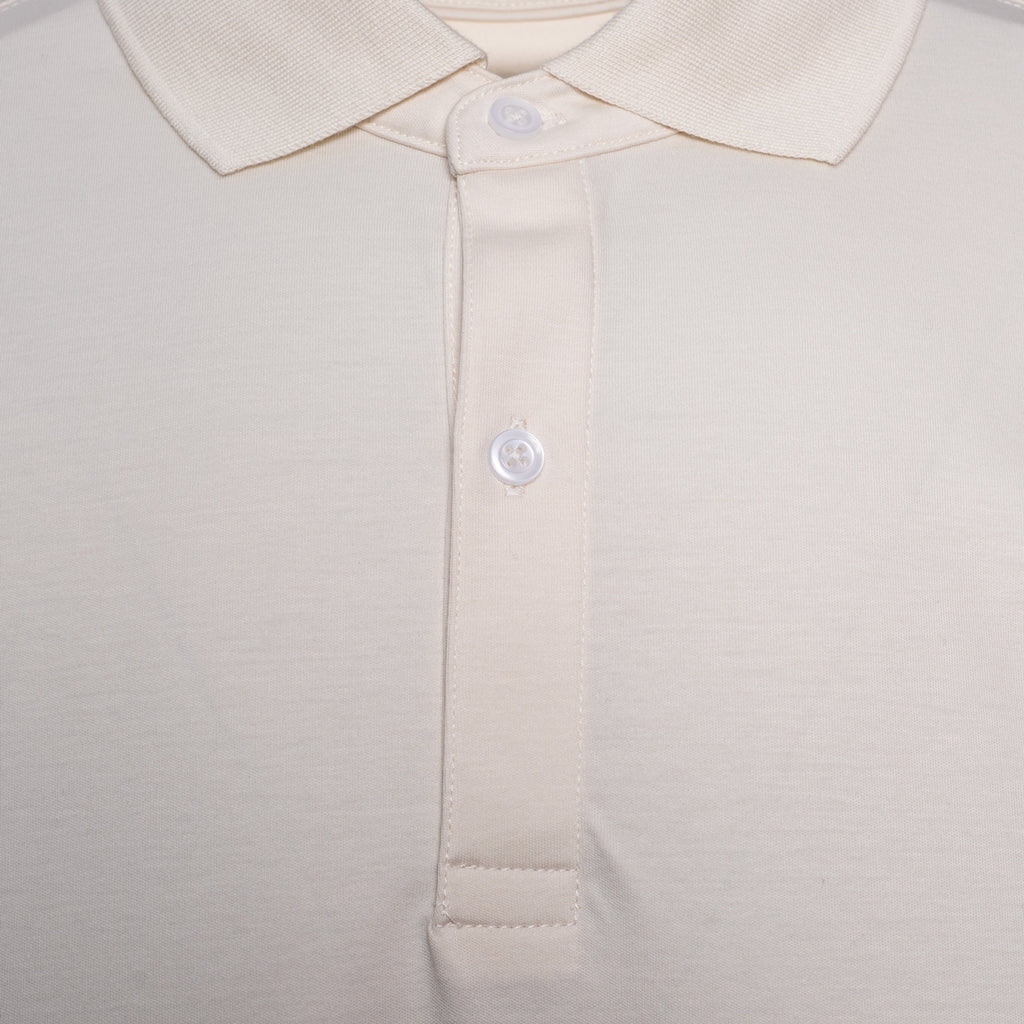 Close-up of a polo shirt collar and button placket in a light cream or off-white color, showing the fabric texture and white buttons. Thomas Maine Polo available at Sakks Menswear in Southampton.