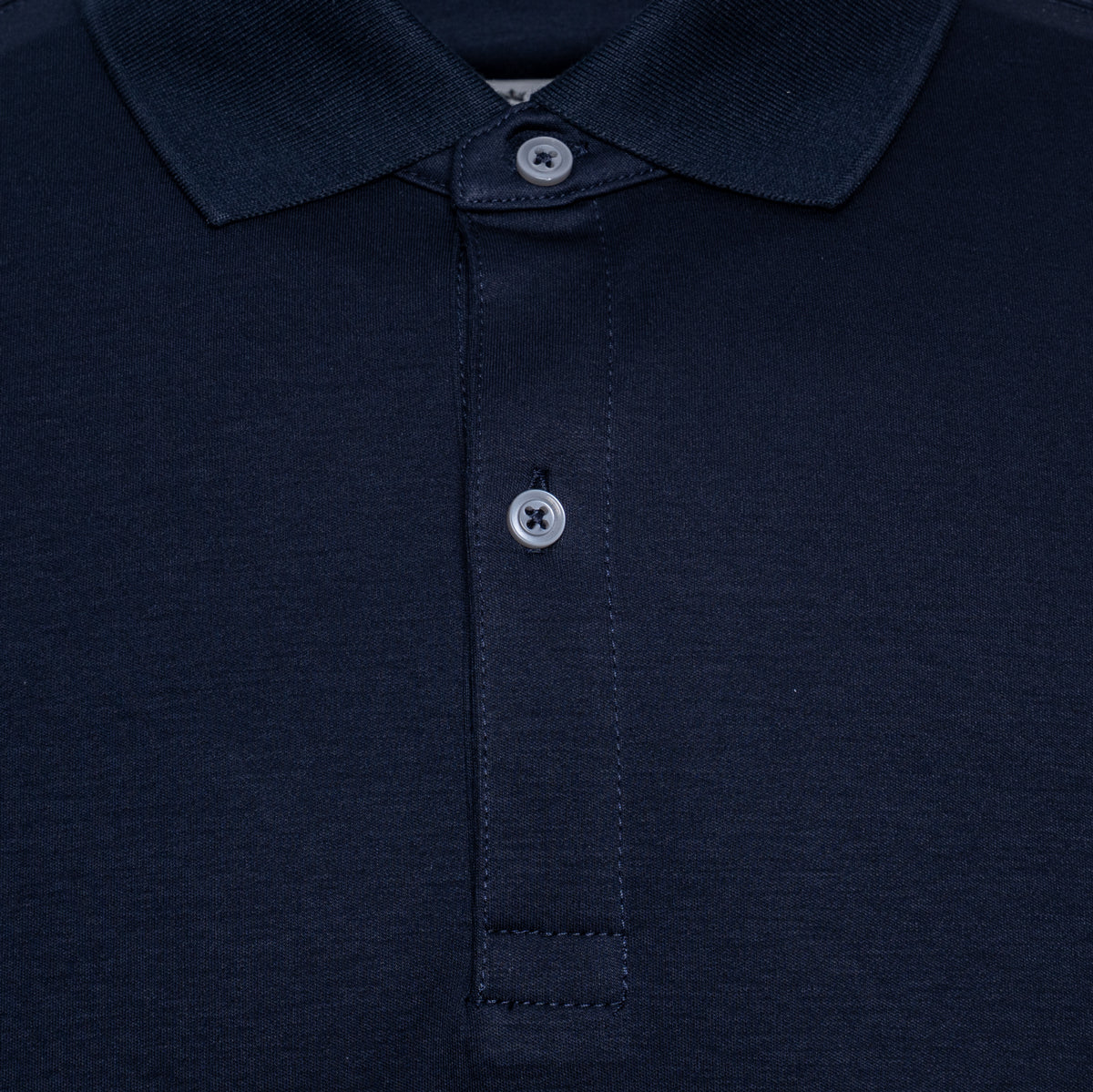 Close-up of a dark navy blue polo shirt showing the collar, button placket, and textured fabric. Thomas Maine Polo available at Sakks Menswear in Southampton.