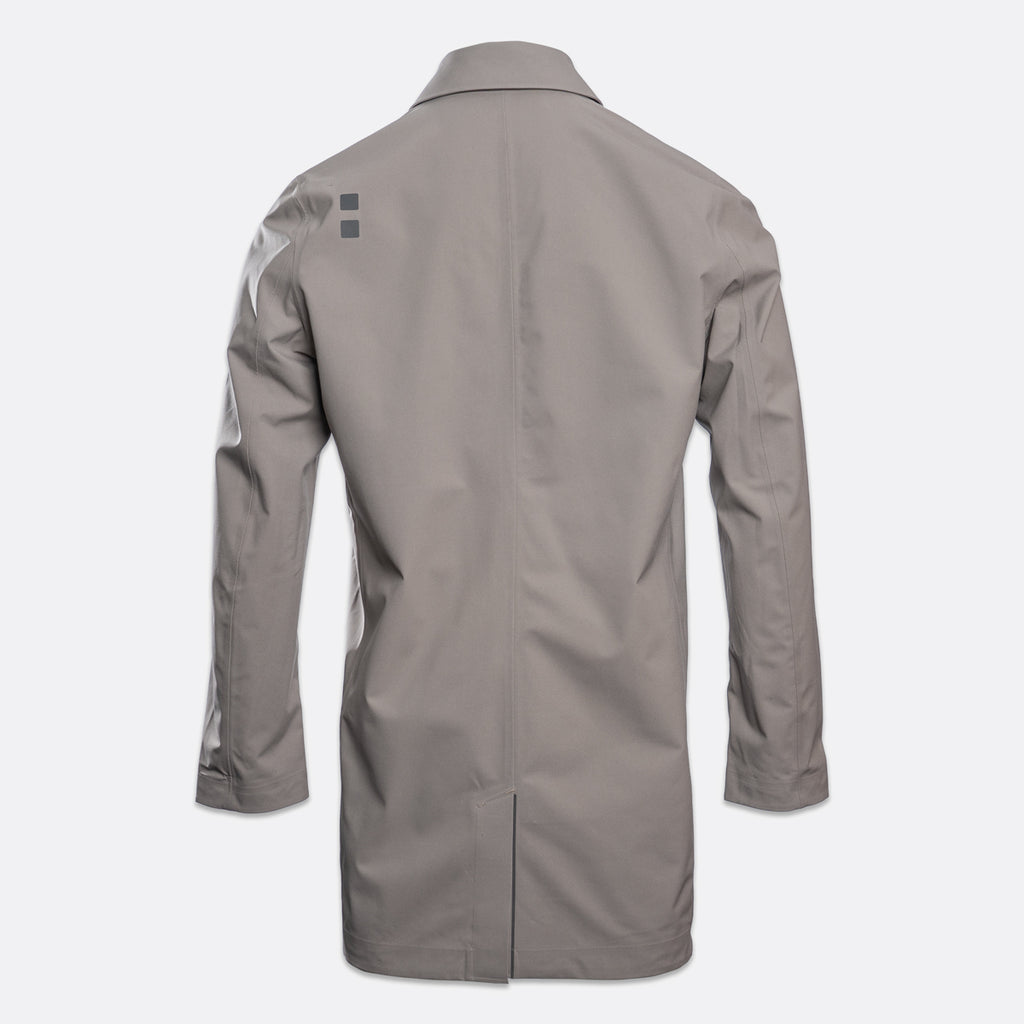 A light gray long-sleeve utility jacket shown from the back, featuring a small dark gray geometric logo on the upper left shoulder, set against a plain light gray background. UBR Jacket available at Sakks Menswear in Southampton.