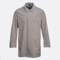 A light gray utility jacket with a pointed collar, long sleeves, and a small square logo patch on the left chest, displayed against a light gray background. UBR Jacket available at Sakks Menswear in Southampton.