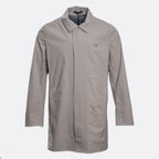 A light gray utility jacket with a pointed collar, long sleeves, and a small square logo patch on the left chest, displayed against a light gray background. UBR Jacket available at Sakks Menswear in Southampton.
