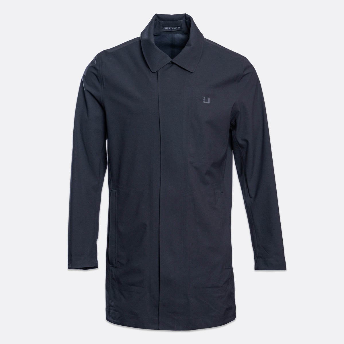 A dark navy blue utility jacket with a pointed collar, front zipper, and a small embroidered logo on the left chest, displayed on a light gray background. UBR Jacket available at Sakks Menswear in Southampton.