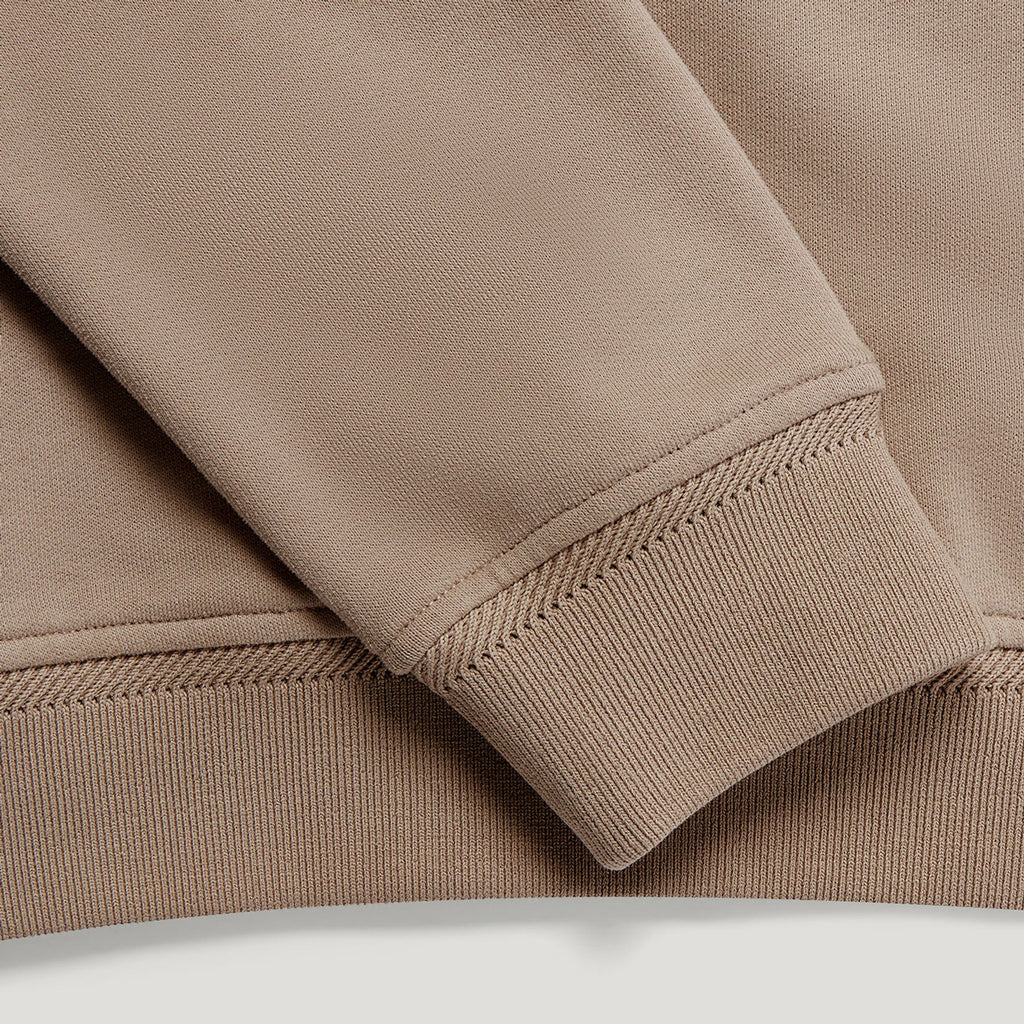 Close-up detail of a crewneck sweatshirt showing the ribbed cuff and hem in a warm taupe-brown colour. Belstaff Sweatshirt. Sakks Menswear Southampton.