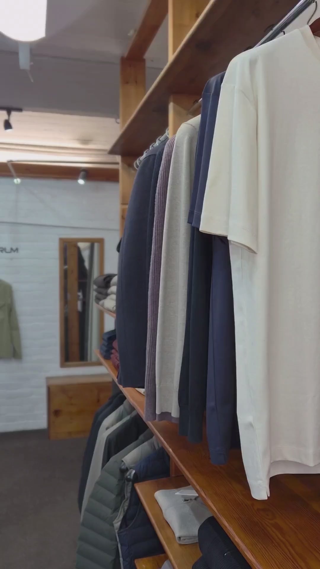 A video showing a model in a shop wearing a long sleeve half zip polo shirt in beige from Profuomo. The model is displaying the details. Profuomo Knitwear is available at Sakks Menswear in Southampton.